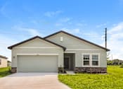 Thumbnail 17 of 75 - A house with a garage and a driveway in front.