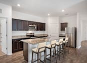 Thumbnail 59 of 63 - A kitchen with a granite countertop and stainless steel appliances.