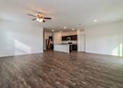 Thumbnail 43 of 75 - A spacious room with a ceiling fan and wooden flooring.