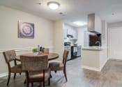 Thumbnail 3 of 24 - Flats at Riverview apartments in Duluth Georgia photo of a dining area with a table and chairs and a kitchen in the background