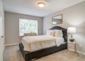 Thumbnail 7 of 24 - Flats at Riverview apartments in Duluth Georgia photo of a bedroom with a bed and two windows
