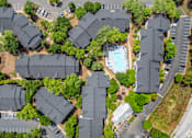 Thumbnail 34 of 34 - Flats on Maple Street A bird's eye view of a residential area with houses, a swimming pool, and a parking lot.