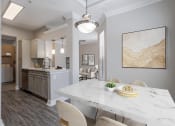 Thumbnail 5 of 20 - Pet-Friendly Apartments in Houston, TX – Gramercy Park – an open kitchen and dining room with a marble table and chairs