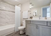 Thumbnail 8 of 20 - Pet-Friendly Apartments in Houston, TX – Gramercy Park – a bathroom with a shower and a toilet and a sink