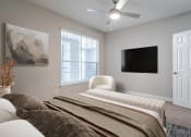 Thumbnail 11 of 20 - Pet-Friendly Apartments in Houston, TX – Gramercy Park – a bedroom with a bed and a ceiling fan
