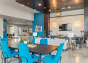 Thumbnail 29 of 43 - a dining area with a table and chairs and a large tv on the wall
