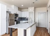 Thumbnail 21 of 43 - a kitchen with white cabinets and a granite counter top
