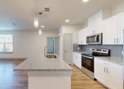 Thumbnail 19 of 43 - a kitchen with white cabinets and a granite counter top