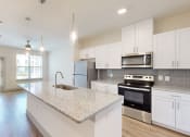 Thumbnail 20 of 43 - a kitchen with white cabinets and a granite counter top