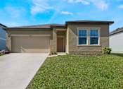 Thumbnail 7 of 63 - A house with a brown garage door and a brown window.