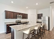 Thumbnail 50 of 63 - A kitchen with brown cabinets and a granite countertop.