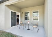 Thumbnail 46 of 63 - A patio with a table and chairs is shown.