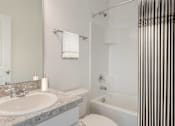 Thumbnail 45 of 63 - A white toilet sits next to a sink in a bathroom.