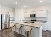 Thumbnail 41 of 63 - A kitchen with a granite countertop and white cabinets.