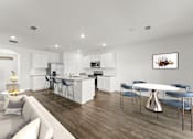 Thumbnail 10 of 35 - A modern kitchen with a dining table and chairs.
