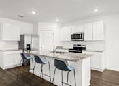 Thumbnail 8 of 35 - A kitchen with white cabinets and a granite countertop.