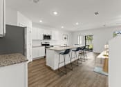 Thumbnail 7 of 35 - A modern kitchen with white cabinets and a central island.