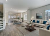 Thumbnail 2 of 14 - Luxury Four Bedroom Townhomes in Avondale Estates, GA - Henley Avondale – living room with a couch and a table and hardwood floors