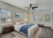 Thumbnail 4 of 14 - Luxury Townhomes in Avondale Estates, GA 30002 for Rent – Henley Avondale - master bedroom with a large bed and a ceiling fan and hardwood floors