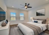 Thumbnail 10 of 14 - Luxury Three Bedroom Townhomes in Avondale Estates, GA – Henley Avondale – bedroom with a bed and a ceiling fan and hardwood flooring