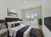 Thumbnail 8 of 14 - Luxury Four Bedroom Townhomes in Avondale Estates, GA - Henley Avondale –bedroom with a large bed and a window and hardwood flooring