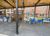 Thumbnail 36 of 40 - Heritage Towers Apartments a patio area with tables and chairs and a television on the wall lewisville tx apartments apartments near lewisville tx lewisville apartments