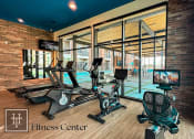 Thumbnail 38 of 40 - Heritage Towers Apartments a gym with cardio equipment and a pool in the background lewisville tx apartments apartments near lewisville tx lewisville apartments