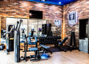 Thumbnail 12 of 40 - a gym with a lot of equipment and a brick wall