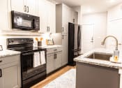 Thumbnail 16 of 40 - a kitchen with black appliances and granite counter tops