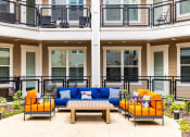 Thumbnail 22 of 40 - a patio with furniture and a table in front of a building