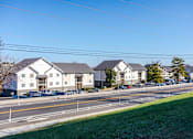 Thumbnail 15 of 17 - Pet-Friendly Apartments in Antioch, TN– Hickory Lake – A row of houses with cars parked in front.