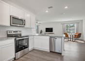 Thumbnail 12 of 35 - A modern kitchen with white cabinets and stainless steel appliances.