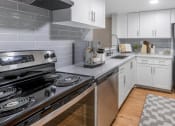 Thumbnail 1 of 23 - Horizons North Apartments in Miami Florida photo of a kitchen with white cabinets and stainless steel appliances