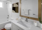 Thumbnail 6 of 23 - Horizons North Apartments near Ojus, Fl photo of a bathroom with a white sink and toilet and a white bathtub