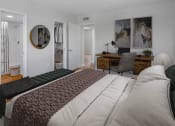 Thumbnail 5 of 23 - Horizons North Apartments near Andover, FL photo of a bedroom with a bed and a desk in a room