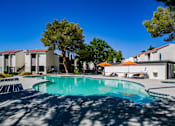 Thumbnail 27 of 36 - a swimming pool with trees and buildings in the background