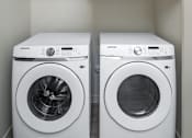 Thumbnail 20 of 47 - Two white front loading washing machines in a laundry room.