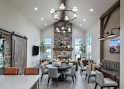 Thumbnail 33 of 47 - A modern dining room with a stone fireplace and a large table set for a meal.