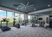 Thumbnail 3 of 47 - A spacious gym with a variety of equipment including treadmills, elliptical machines, and weight racks.