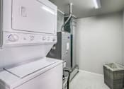 Thumbnail 27 of 27 - A white oven and dryer in a small laundry room.