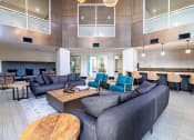 Thumbnail 19 of 33 - a lobby with couches tables and chairs and a kitchen