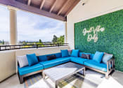 Thumbnail 17 of 33 - a patio with blue couches and a table and a green wall
