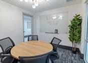Thumbnail 32 of 33 - a conference room with a round table and a large potted plant