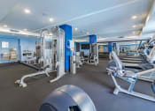 Thumbnail 26 of 33 - a gym with cardio equipment and weights at the apartments