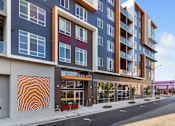 Thumbnail 5 of 20 - A modern building with a large mural on the side.