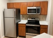 Thumbnail 1 of 25 - a kitchen with stainless steel appliances and wooden cabinets