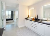 Thumbnail 13 of 29 - A modern bathroom with a large mirror and a vanity with a sink.
