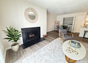 Thumbnail 7 of 35 - A living room with a fireplace and a plant.