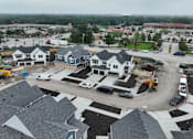 Thumbnail 14 of 14 - A construction site with several houses and vehicles.