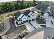 Thumbnail 5 of 14 - A large white house with a black roof is surrounded by a red fence.
